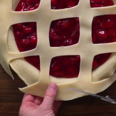 someone is cutting into a pie with cherries on it