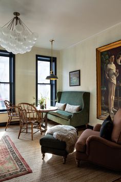 a living room filled with furniture and a painting hanging on the wall above it's windows