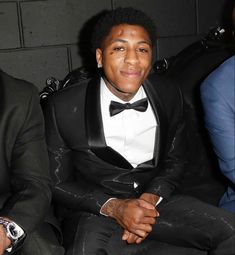 a man in a tuxedo sitting next to another man