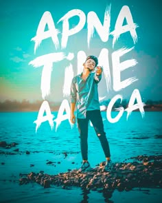 a man standing on top of a rock covered beach next to the ocean with text that reads, apna time aaga