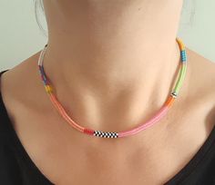 a woman wearing a multi colored beaded necklace