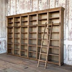 an old wooden bookcase with ladder leaning against it