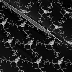 black and white photograph of an umbrella with vines on the outside, in front of a dark background