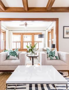 a living room with two couches and a coffee table in front of a window