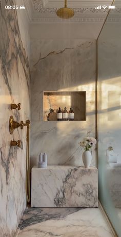 a bathroom with marble and gold fixtures