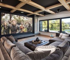 a living room with couches and a large screen on the wall