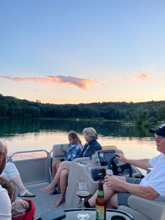 people are sitting on a boat in the water at sunset or dawn with drinks and snacks