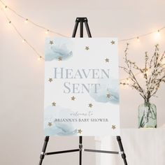 an easel with a sign that says heaven sent on it and lights in the background