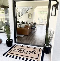 a door mat with the words family on it in front of a living room and stairs