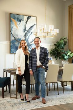 a man and woman standing next to each other in front of a dining room table