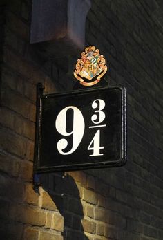 a black and white sign hanging from the side of a brick building