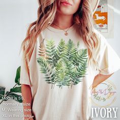 a woman wearing a t - shirt with a fern print on the front and back