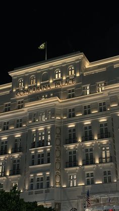 a large white building lit up at night with lights on the front and side windows