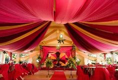 the interior of a banquet hall decorated with red and yellow draping