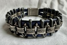 This rugged unisex bracelet looks great on just about anybody! This piece is handmade of sapphire blue embossed strap leather, silver chain, silver leather cord and finished with a metallic clasp for easy on and off. Fits a size 6.5 inch wrist snugly, but not tight.  Please note sizing! To measure your wrist, take a tape measure and wrap it snugly (with no slack) around your wrist. (I build in extra space for it to hang/fit properly.) If you have questions, please contact me! I'm happy to make a custom size for you. Handmade Leather Silver Bracelets, Handmade Leather Silver Bracelet, Handmade Silver Leather Bracelets, Hand-tooled Silver Leather Jewelry, Unique Silver Leather Bracelet, Adjustable Silver Hand Tooled Leather Bracelet, Leather Cuff Bracelet, Chain Silver, Unisex Bracelets