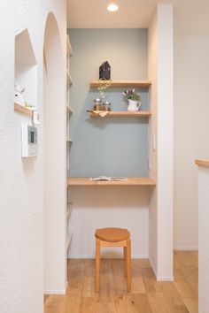 an empty room with shelves and a small stool in the corner next to it on top of a hard wood floor