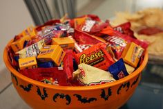 an orange bowl filled with halloween candy and crackers