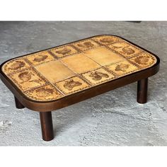 a small wooden table with tile on it