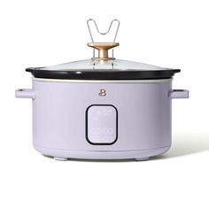 an electric crock pot with the lid open and a gold handle on it's side