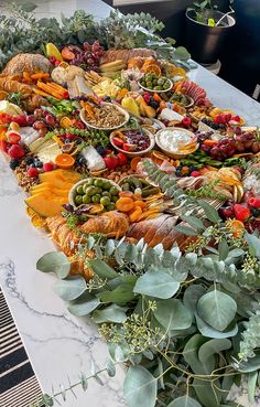 a table topped with lots of different types of food and plants on top of it