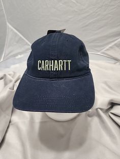 Add a touch of outdoor style to your wardrobe with this Carhartt Navy Blue Script Hat. Made from lightweight and breathable cotton canvas fabric, this baseball cap is perfect for travel, casual wear, or workwear. The adjustable strap ensures a comfortable fit for all sizes, while the solid blue color and script logos add a touch of vintage charm. Designed for men, this hat is perfect for outdoor enthusiasts who love to explore and enjoy the great outdoors. Made in Bangladesh, this Carhartt hat i Carhartt Baseball Hat, Carhartt Hat, Cotton Canvas Fabric, Money And Happiness, Script Logo, Outdoor Style, Great Outdoors, The Great Outdoors, Baseball Cap