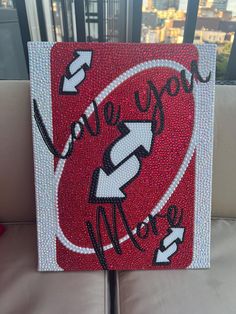 a red and white painting with the word love you more on it