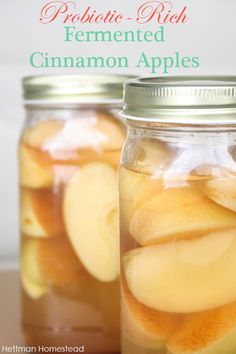 two jars filled with sliced apples on top of a table