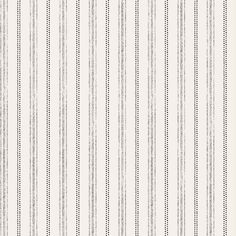 a white and grey striped wallpaper with small black dots on the bottom half of it