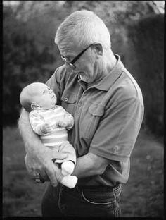 an older man holding a baby in his arms