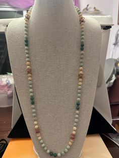 This 36 inch jade and coral necklace can be doubled up to make two strands. The jade beads are light green and dark green and the coral beads are pink, lavender and terracotta between the gold colored square spacers. Green Single Strand Beaded Necklace In Amazonite, Green Amazonite Single Strand Beaded Necklace, Spiritual Green Necklace With Wooden Beads, Green Spiritual Necklace With Wooden Beads, Multicolor Jade Round Bead Necklaces, Green Faceted Jade Beaded Necklaces, Multicolor Jade Beaded Necklaces, Multicolor Jade Necklaces With Natural Stones, Multicolor Beaded Jade Necklaces