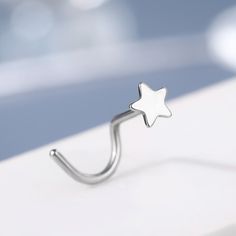 a silver nose ring with a star on it