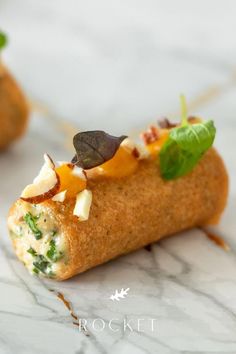 an appetizer with cheese, spinach and other toppings is on a marble surface