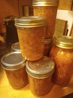 several jars filled with food sitting on top of a wooden table next to each other