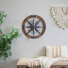 a clock mounted to the side of a wall next to a bench and potted plant