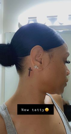 a woman with a cross tattoo on her ear