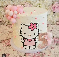 a hello kitty birthday cake with pink and white decorations