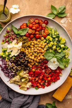 a white plate topped with lots of veggies and beans next to a glass of green juice