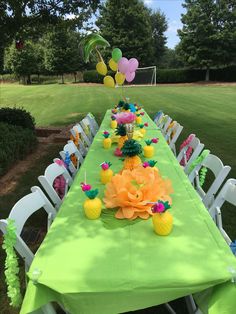 a long table with pineapples and balloons on it