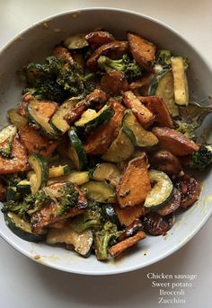 a white bowl filled with cooked vegetables on top of a table