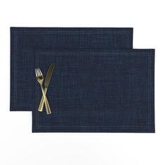 two placemats with gold forks and knife on them, against a white background