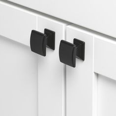 two black handles on white cabinet doors