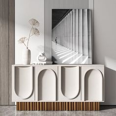 a white sideboard with two vases and a mirror on the wall next to it