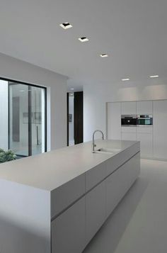 an empty kitchen with white cabinets and counter tops is pictured in this image, there are no people around