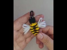 a hand holding a small stuffed bee in it's palm