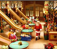 a santa clause is standing in the middle of a room filled with children's toys