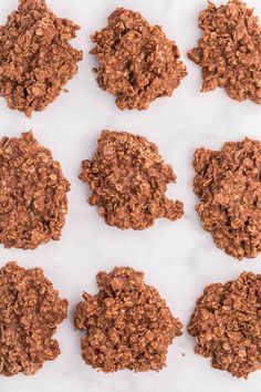 chocolate cookies are arranged in rows on a white surface