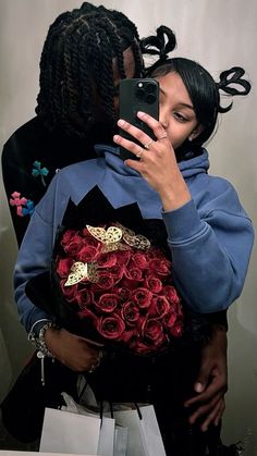 a woman taking a selfie with her cell phone while holding a bouquet of roses