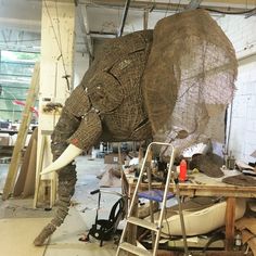 an elephant statue is being worked on in a shop with tools and materials around it