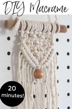 the macrame wall hanging is made with white yarn and wood beads