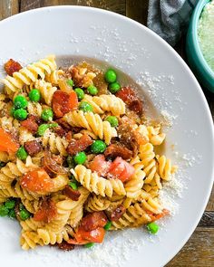 a white plate topped with pasta and peas